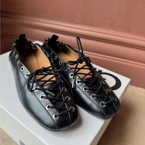 Black Ganni lace-up ballet flats.